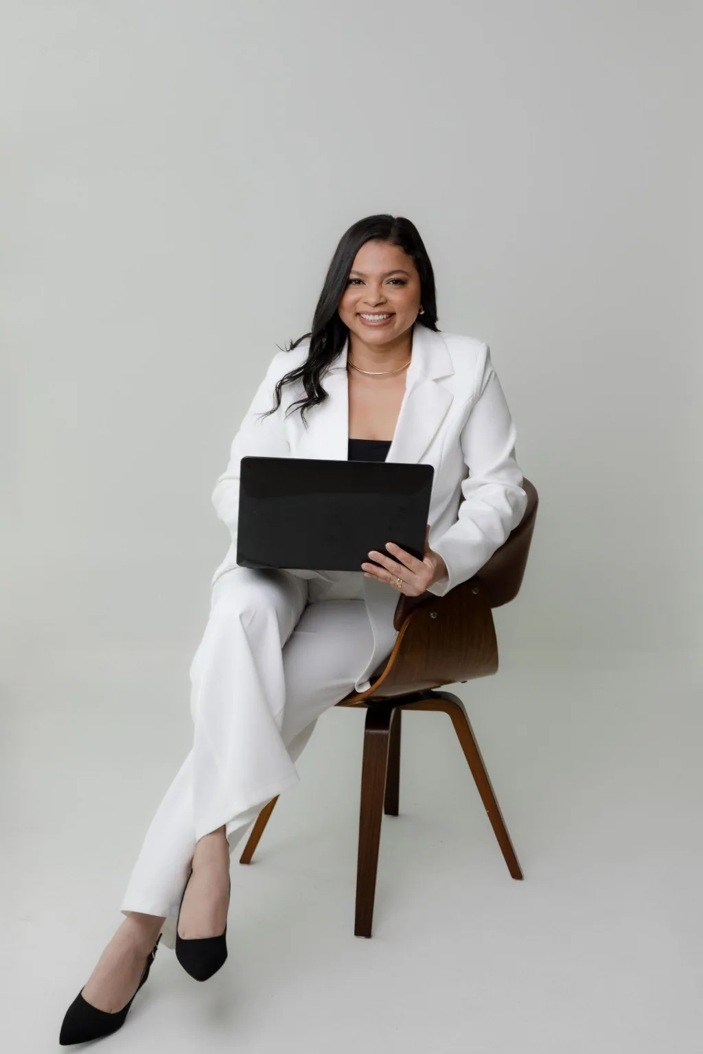 Leílza Cardoso sentada com notebook em ambiente profissional